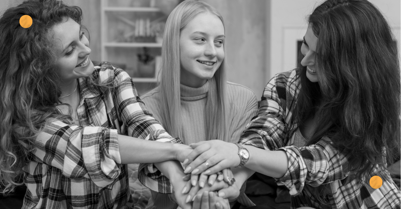 Three girls holding their hands together, showing their trust and friendship.