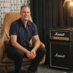 Matt Turner, Client Strategist and Account Manager at Beacon Collective Inc., sitting in leather chair, by a Marshall speaker and a golden palm-tree shaped lamp.
